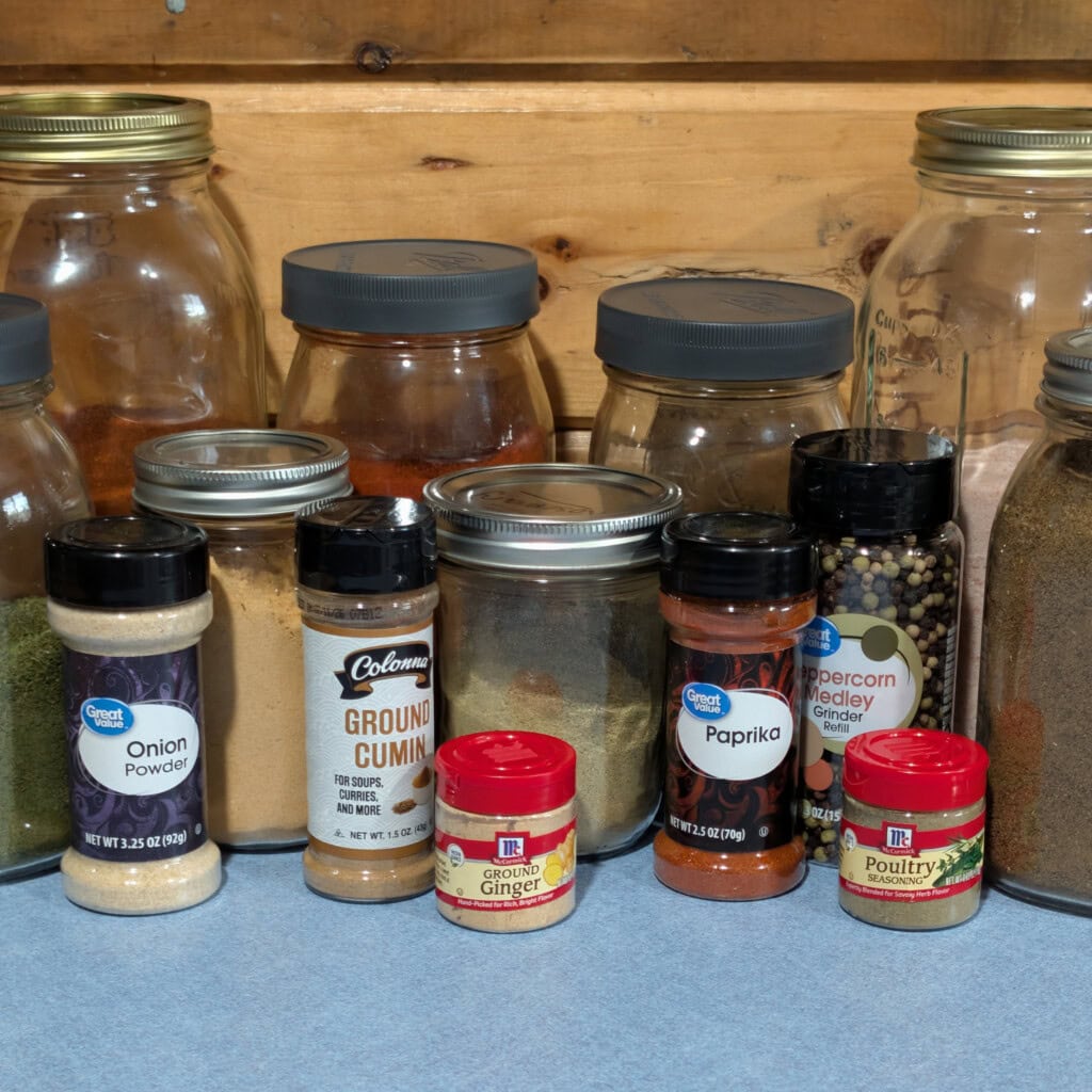 Bulk seasonings in canning jars with smaller seasoning bottles in front on kitchen counter