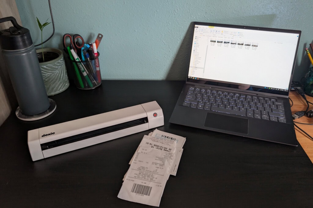 Laptop, portable scanner and documents on desk waiting to be scanned
