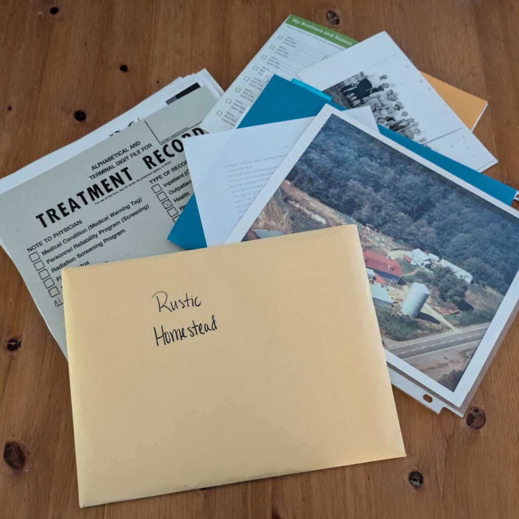 Folders containing documents, medical records, and family history on table
