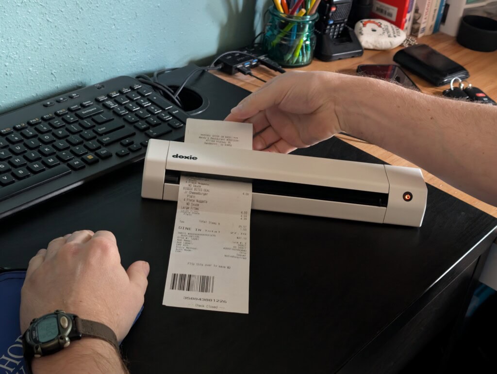 Person scanning a receipt with a portable scanner