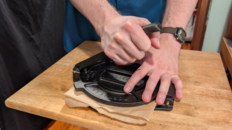 Adult hands working a tortilla press to create homemade tortillas