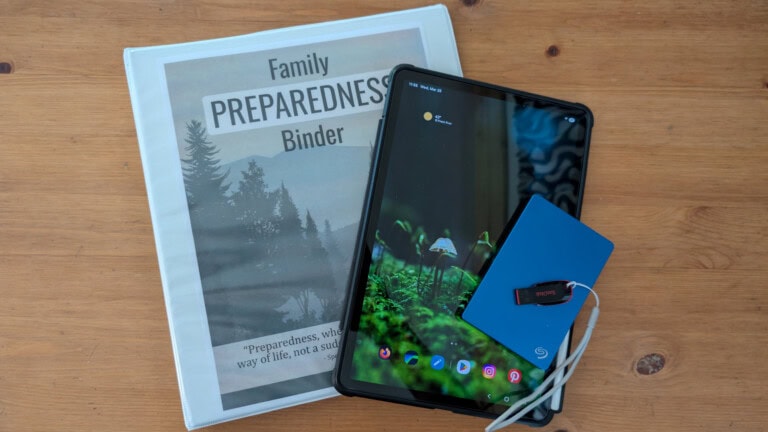Preparedness binder, tablet and digital vault on wooden table