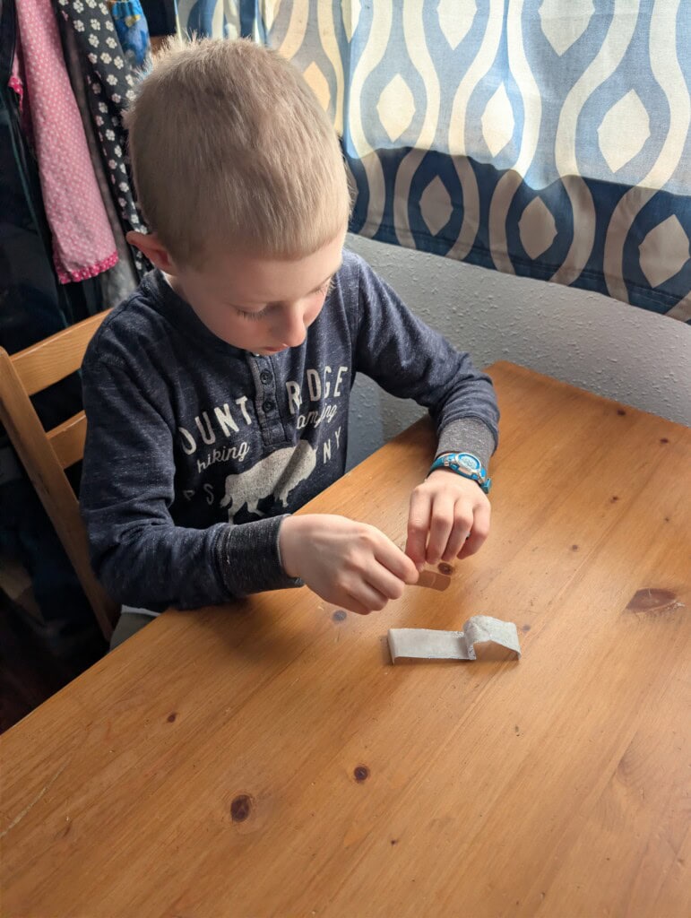 Child applying bandage from his EDC kit without help