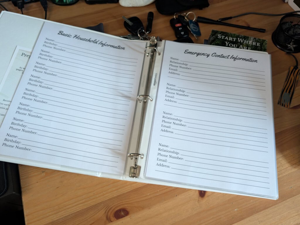 Family Preparedness Binder on table with blank emergency contact pages