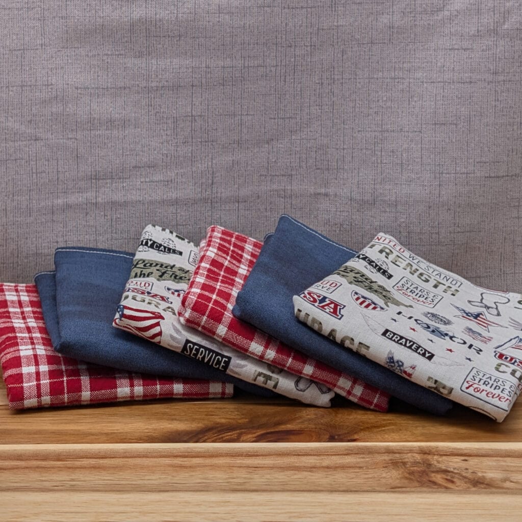 Set of fanned out reusable paper towels on wooden board in the freedom pattern
