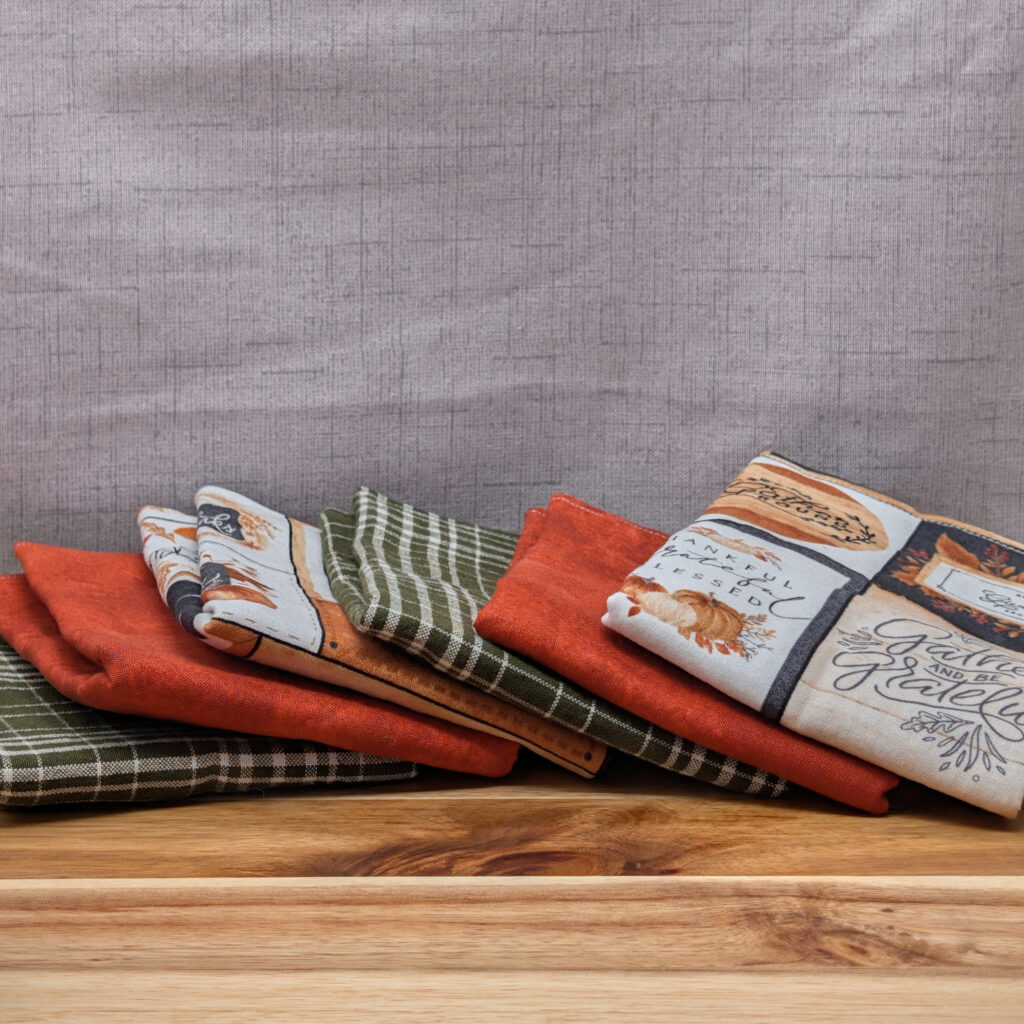 Set of fanned out reusable paper towels on wooden board in the give thanks pattern