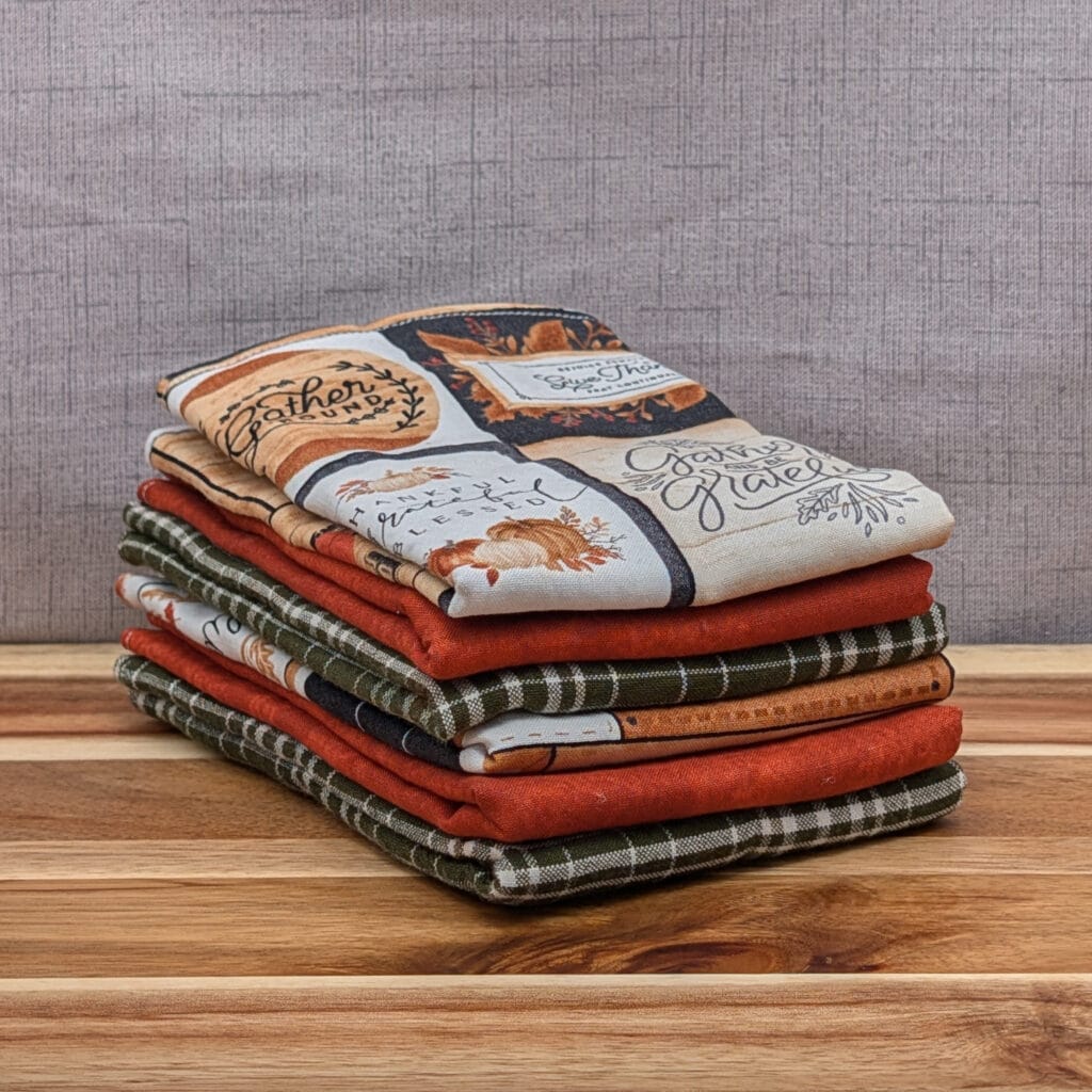 Set of folded reusable paper towels on wooden board in the give thanks pattern