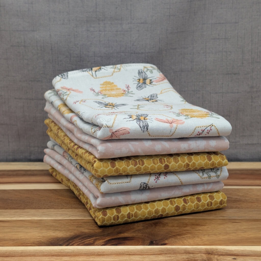 Set of folded reusable paper towels on wooden board in the honey bee pattern