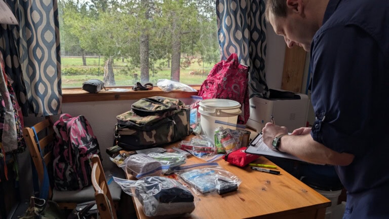 Father doing inventory on child's rolling 72-hour kit