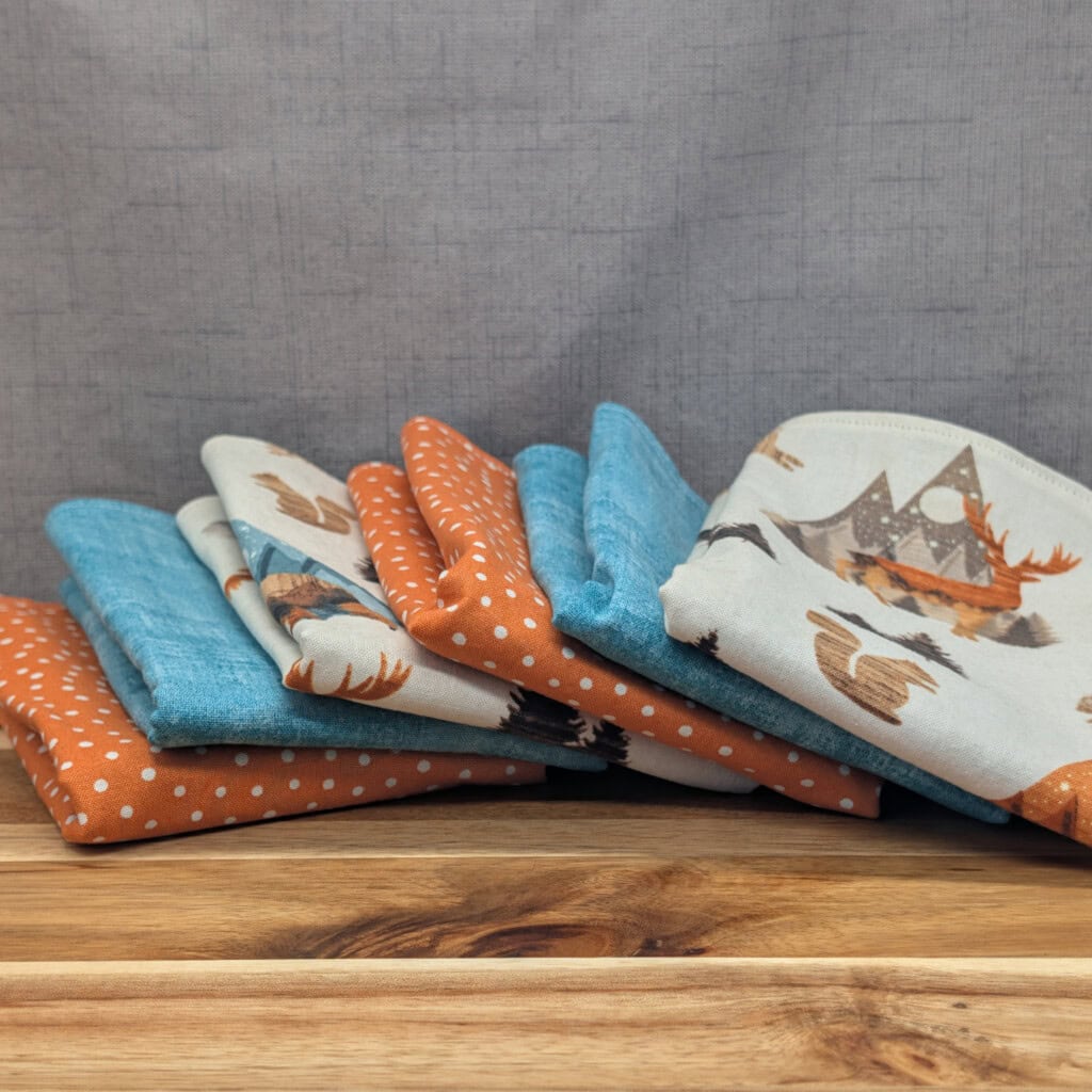Set of fanned out reusable paper towels on wooden board in the mountain critters pattern