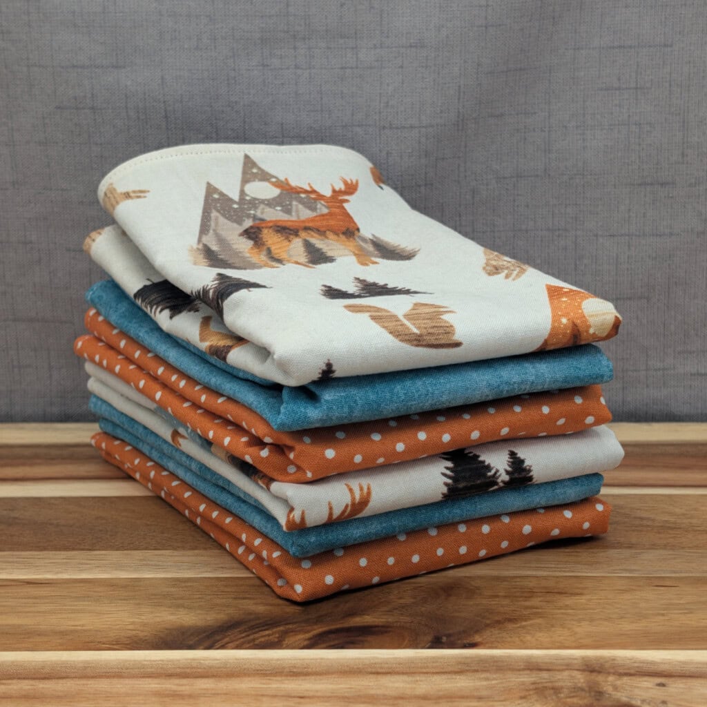 Set of folded reusable paper towels on wooden board in the mountain critters pattern