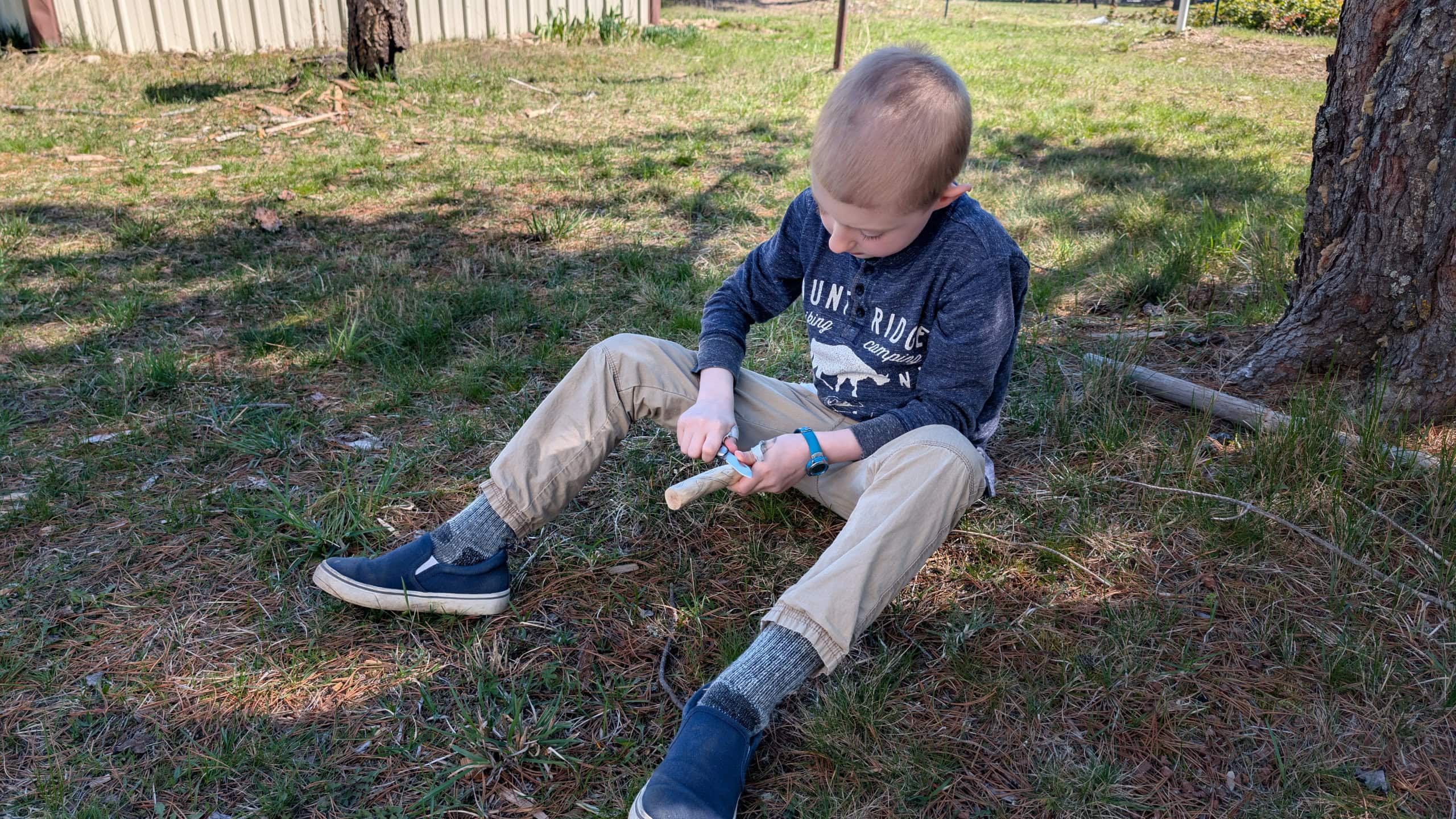 Child learning how to use the knife in his kids EDC kit safely