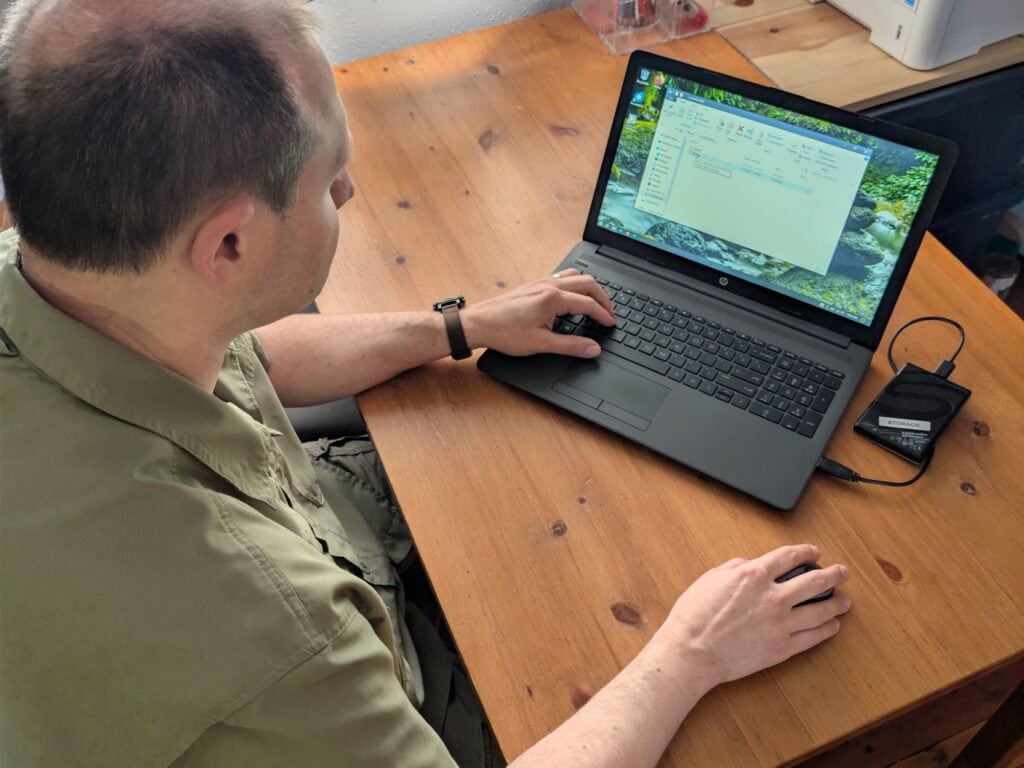Dad backing up a computer to a local storage 'root cellar' drive