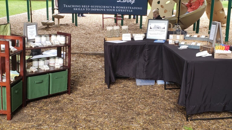 Outdoor event vendor booth setup with candles and handmade products