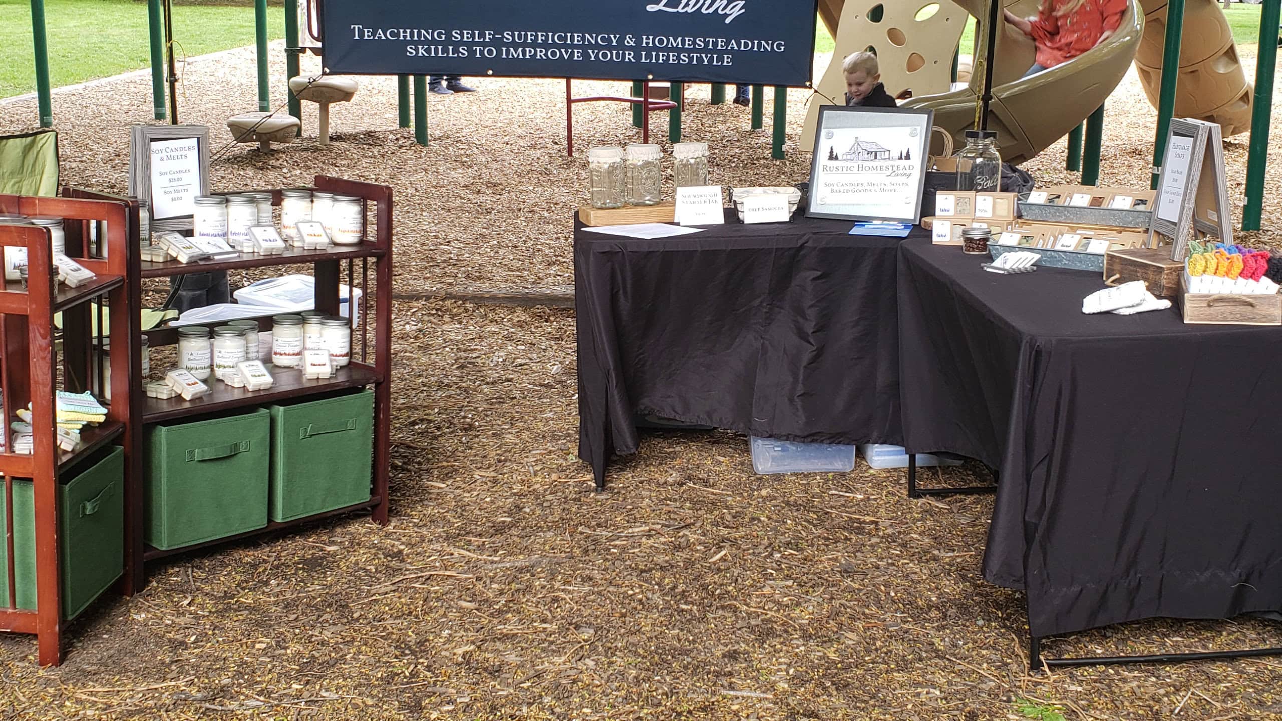 Outdoor event vendor booth setup with candles and handmade products