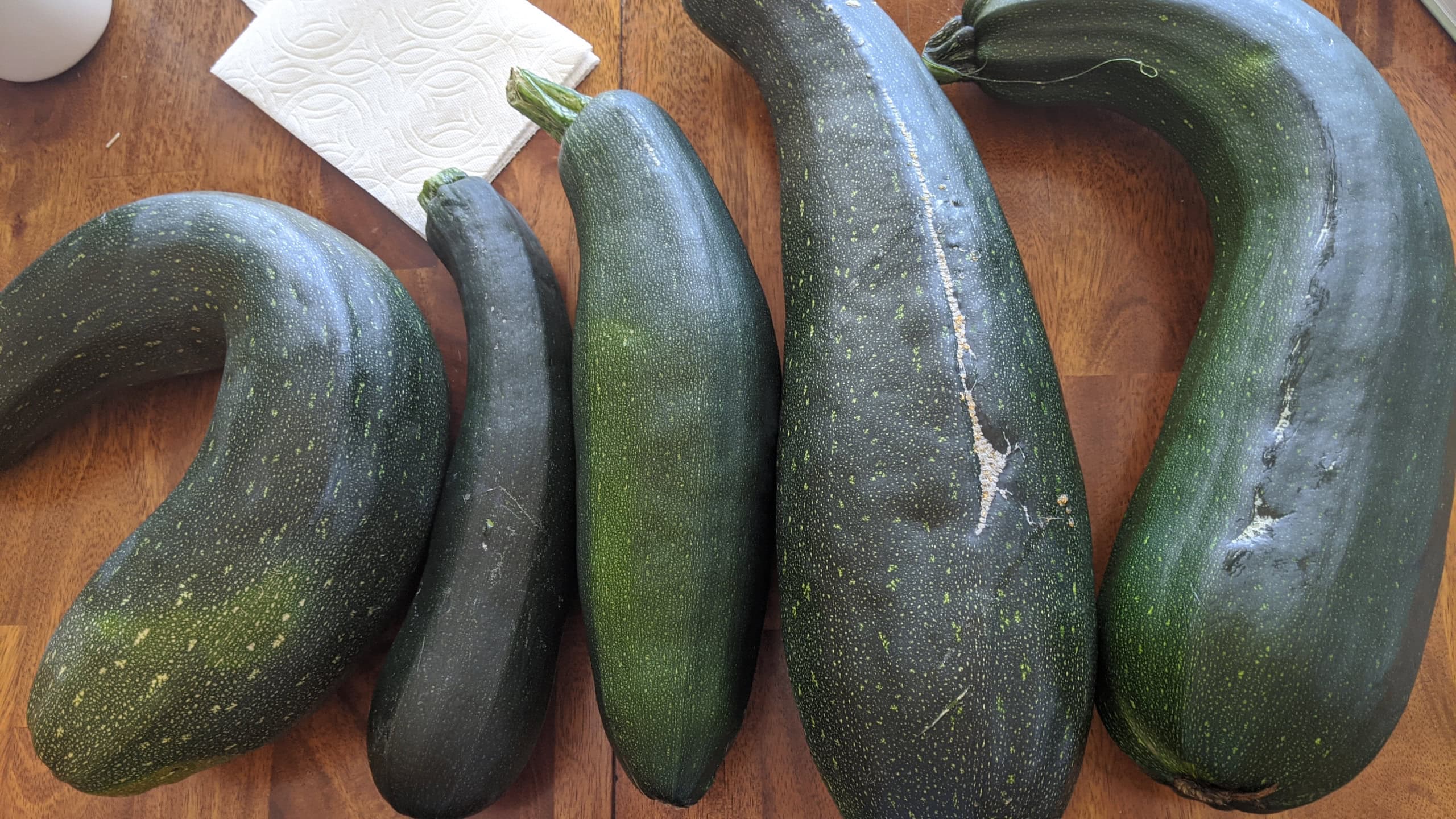 Zucchini lined up on a wooden table