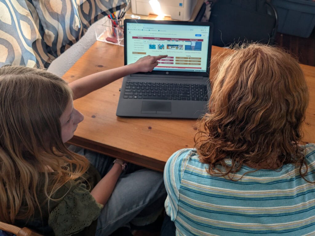 Mom teaching daughter how to browse a website safely