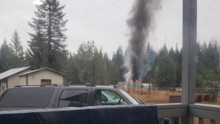 Dark smoke and fire on the horizon viewed from porch