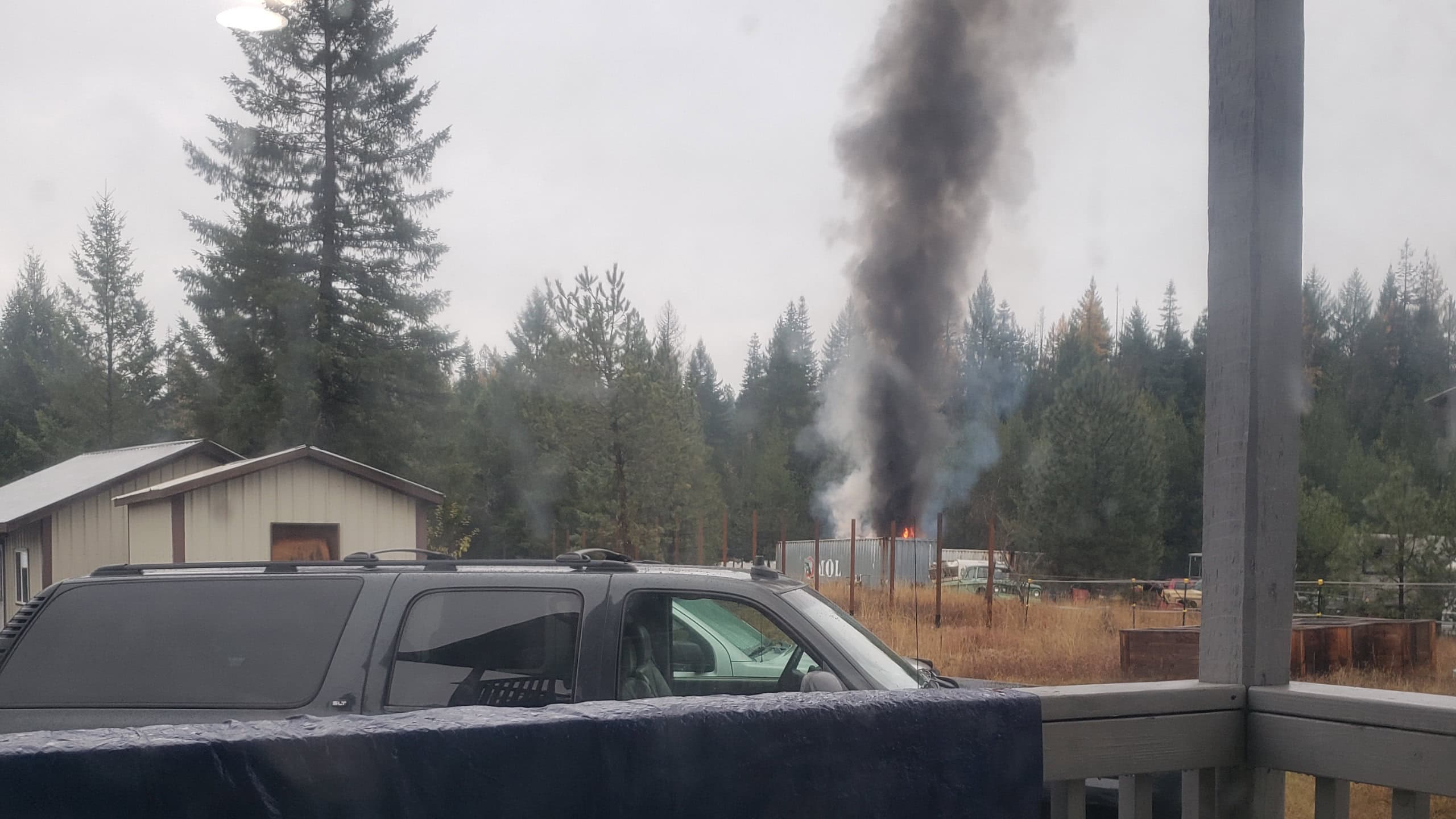 Dark smoke and fire on the horizon viewed from porch