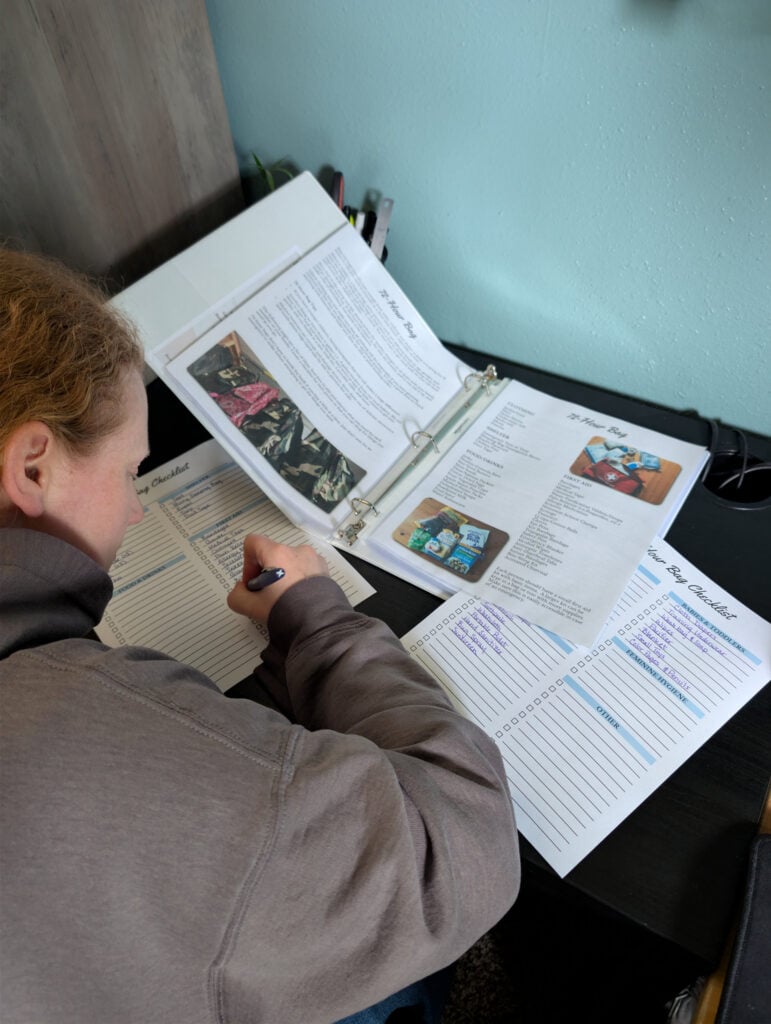 Woman writing lists on paper preparedness system