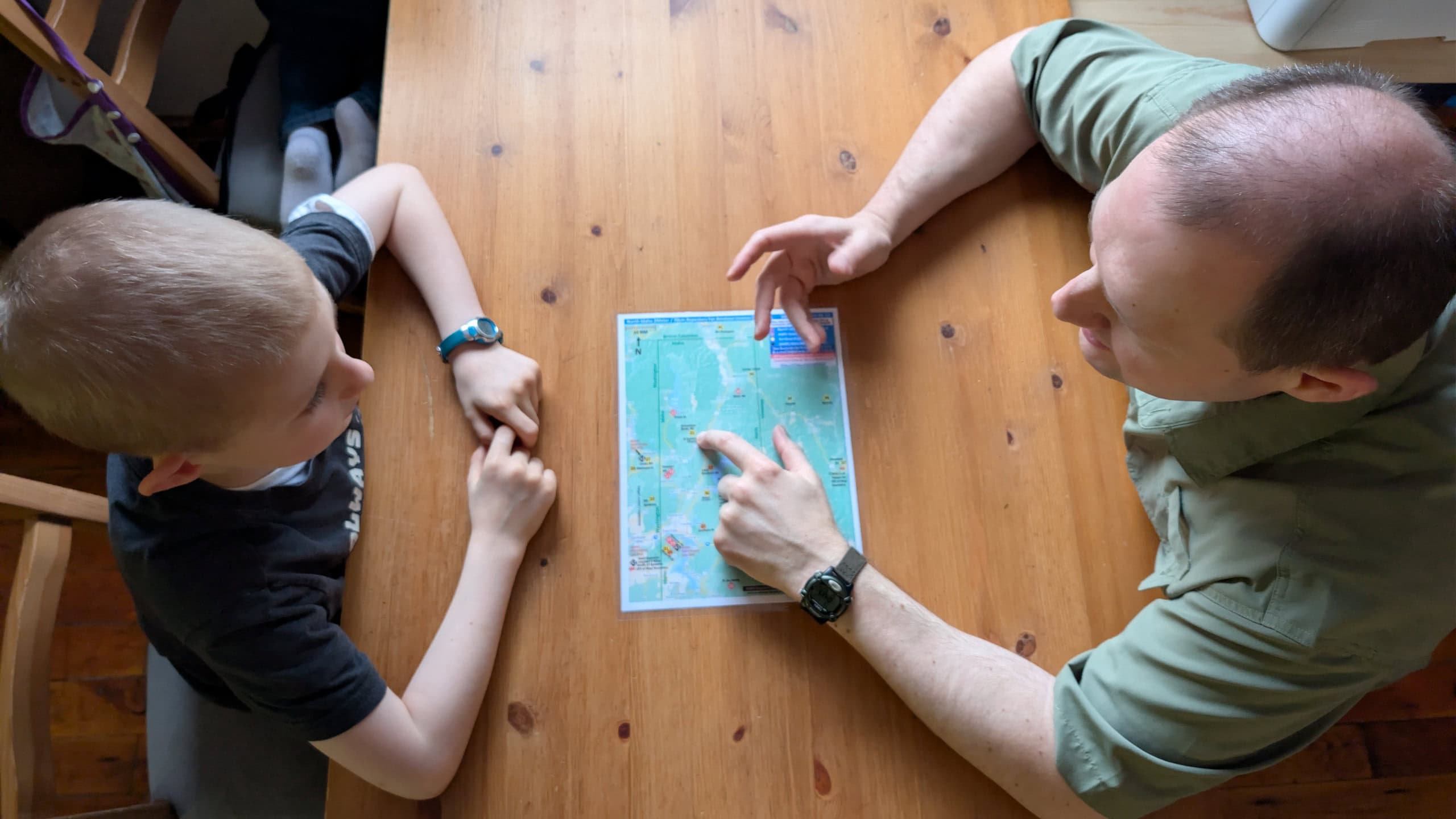 Father teaching his son how to run the radio network with map on table