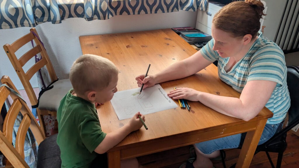 Toddler and mom drawing evacuation plan on paper