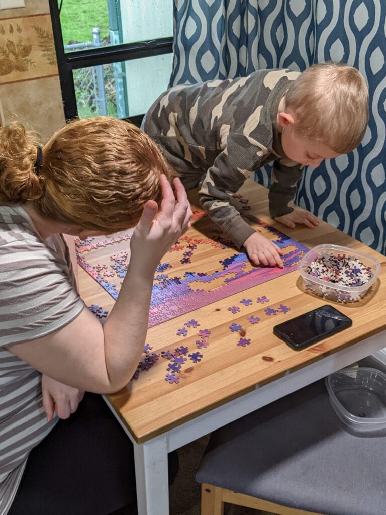 Mom and son building puzzle on table during a power outage