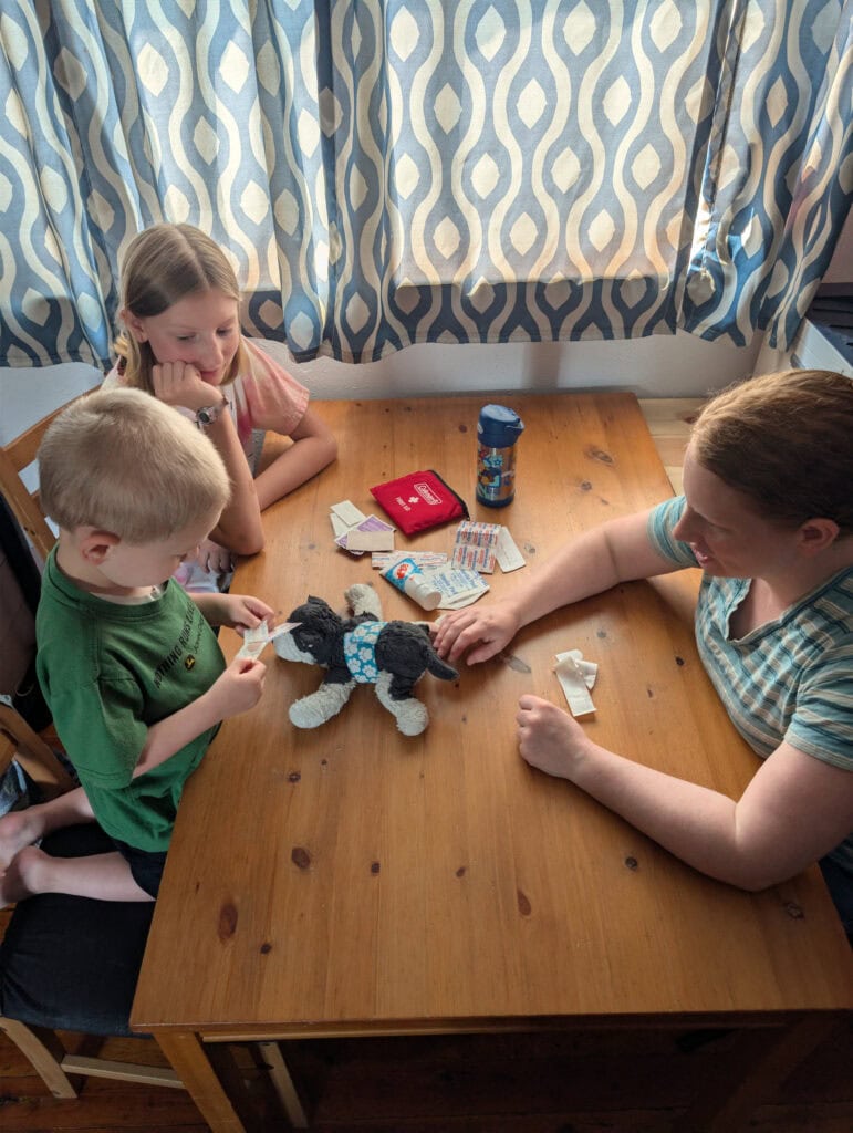 Young boy and girl learn how to apply basic first aid to an animal