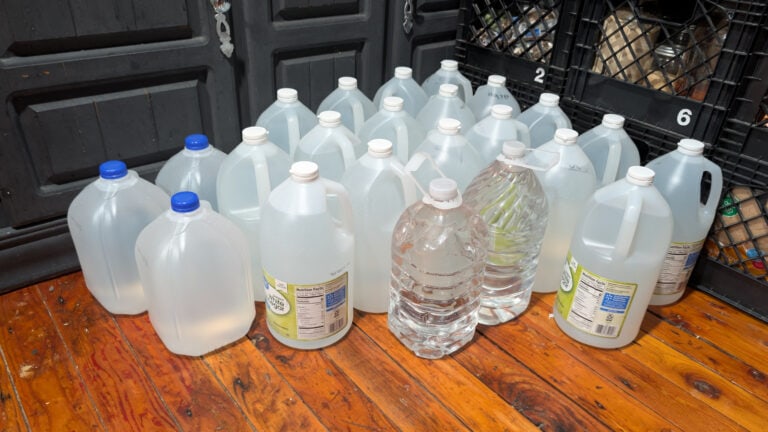 Gallons of water in random jugs stacked in a corner