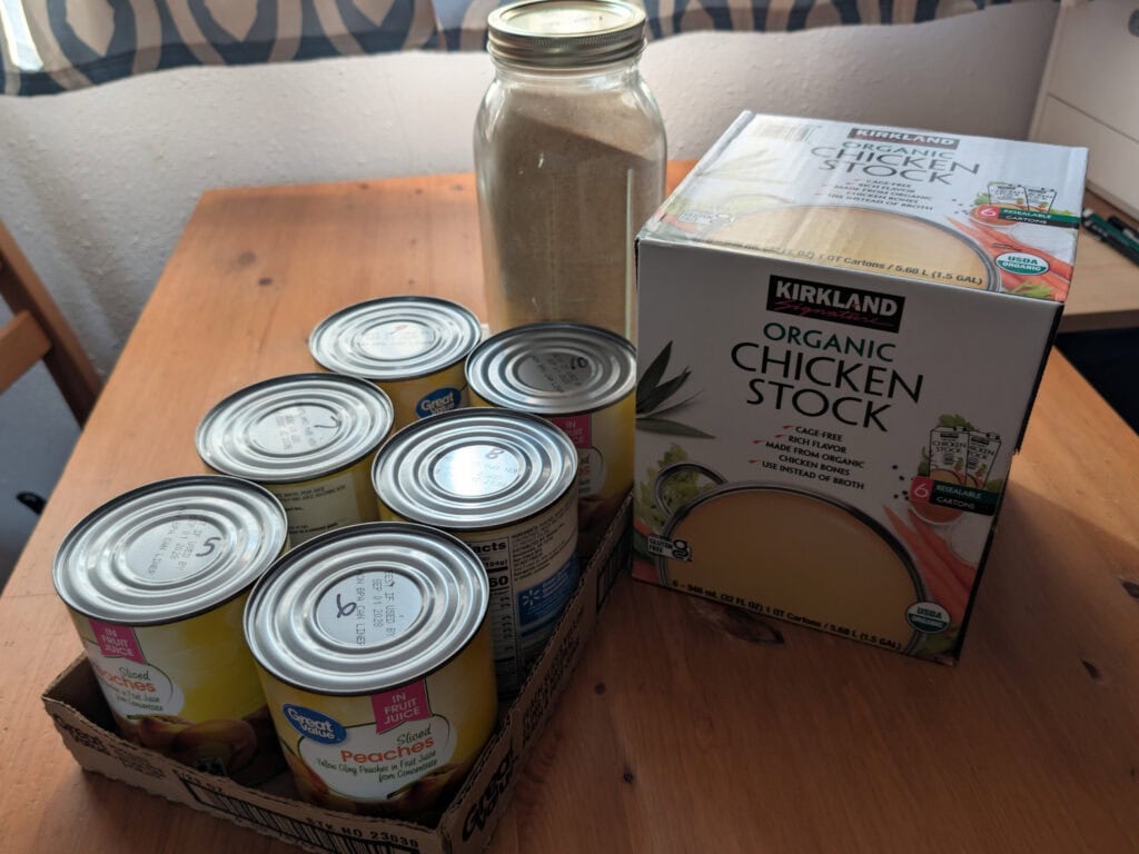 Canned food, boxed broth and bulk seasonings on table