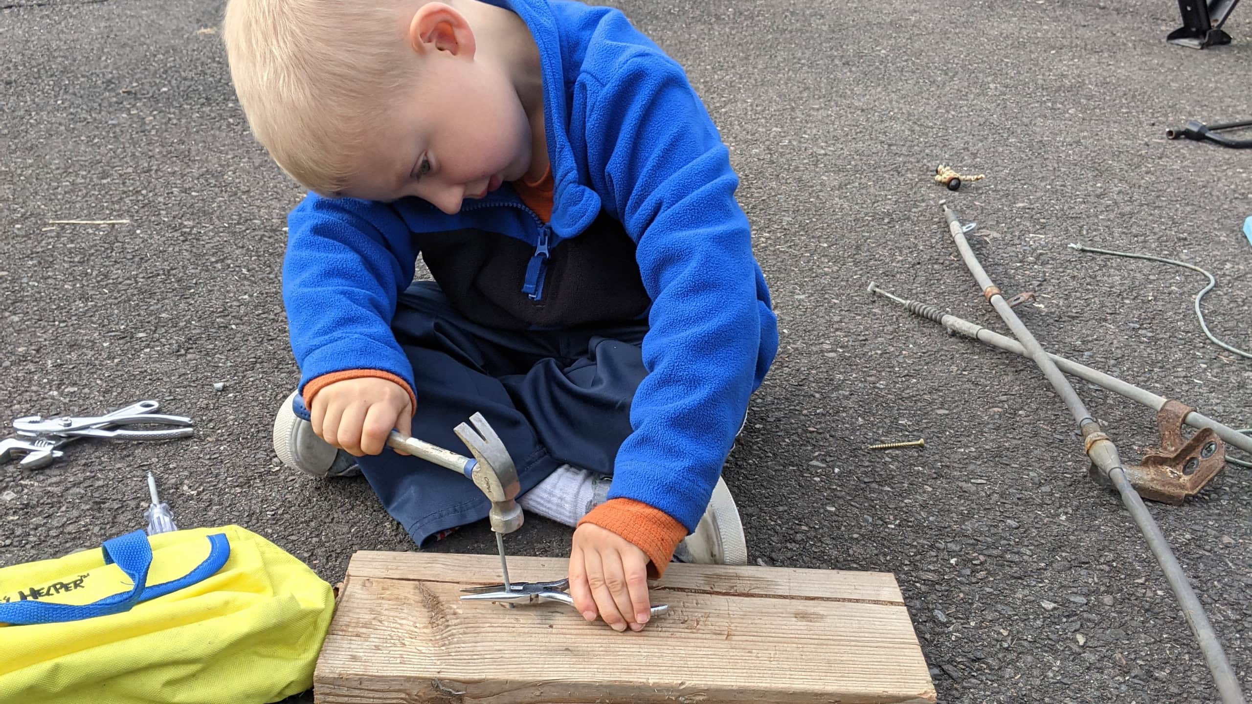 Young boy learning how to use a hammer